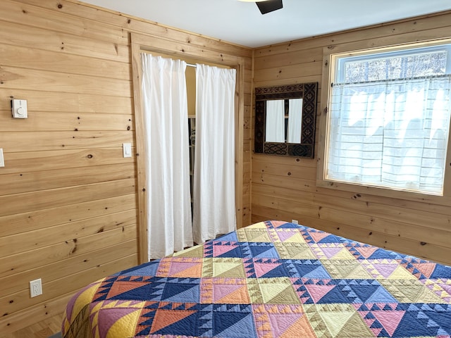 bedroom featuring wooden walls and ceiling fan