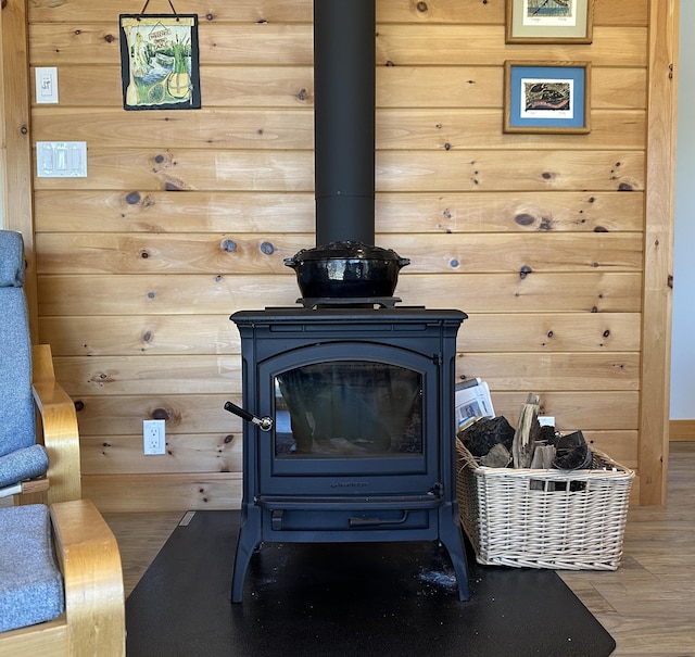 details featuring wood walls, wood finished floors, and a wood stove