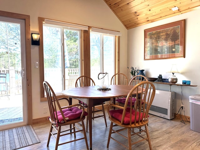 dining room with light wood finished floors, vaulted ceiling, and wooden ceiling