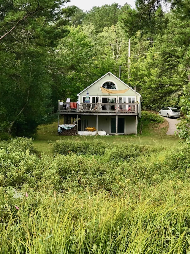 back of property with a forest view and a wooden deck