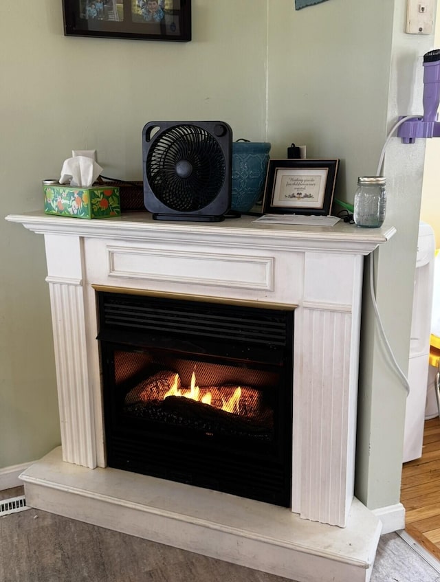 1002 River Rd, Orrington, ME 04474 - details with a warm lit fireplace and wood finished floors