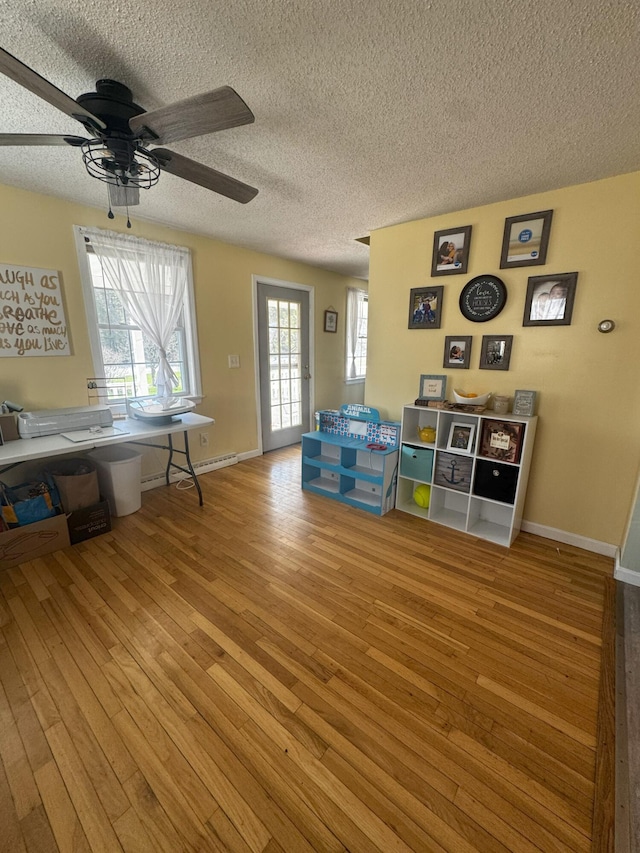 1002 River Rd, Orrington, ME 04474 - interior space with baseboards, a ceiling fan, a textured ceiling, and hardwood / wood-style flooring
