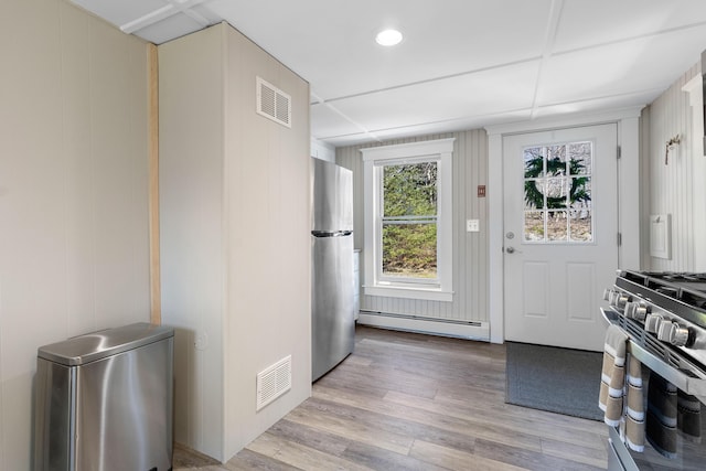 interior space featuring visible vents, light wood finished floors, and a baseboard radiator