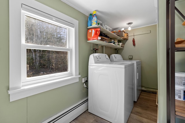 washroom with laundry area, washing machine and dryer, baseboard heating, and wood finished floors