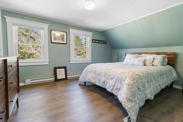 bedroom with baseboards, a baseboard radiator, wood finished floors, and lofted ceiling