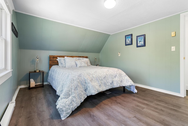 bedroom featuring baseboards, a baseboard heating unit, and wood finished floors