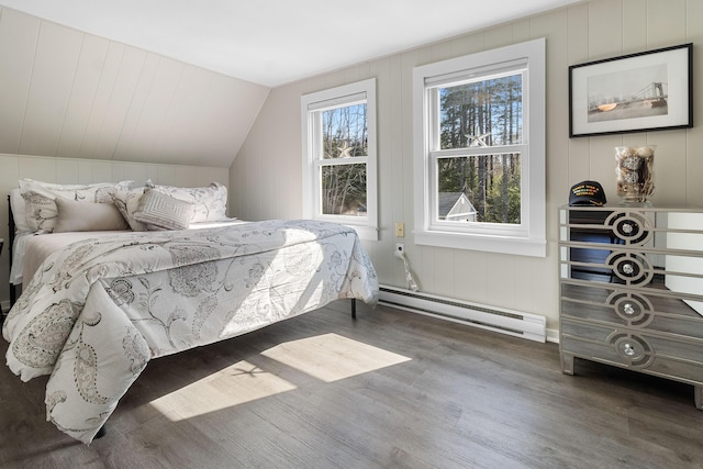bedroom featuring a baseboard radiator, vaulted ceiling, and wood finished floors