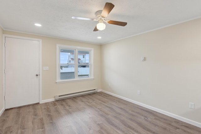 spare room with ceiling fan, baseboards, a baseboard radiator, and wood finished floors