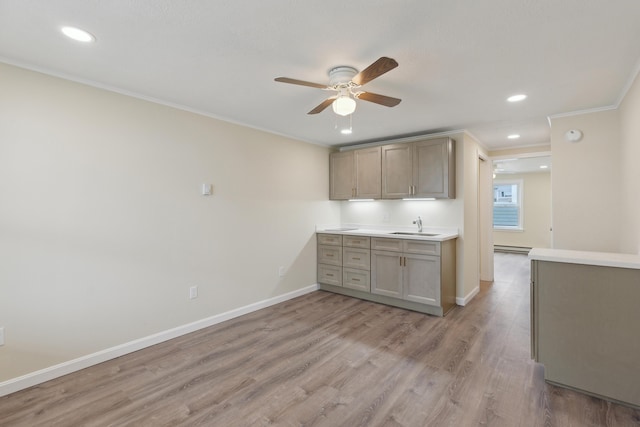 kitchen with a sink, light wood-style floors, a ceiling fan, recessed lighting, and ornamental molding
