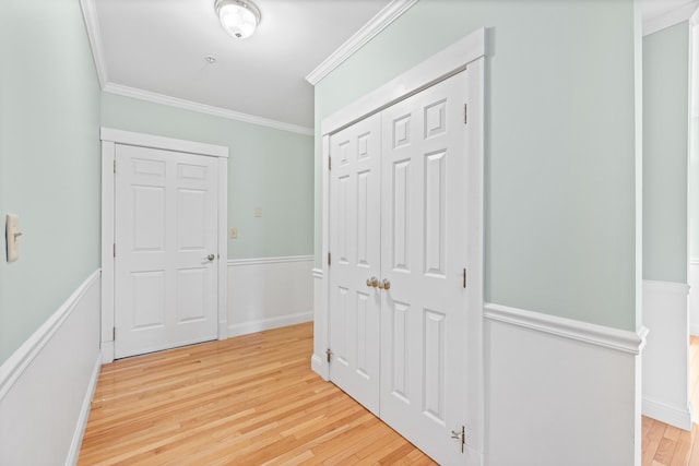 hallway with ornamental molding and light wood-type flooring