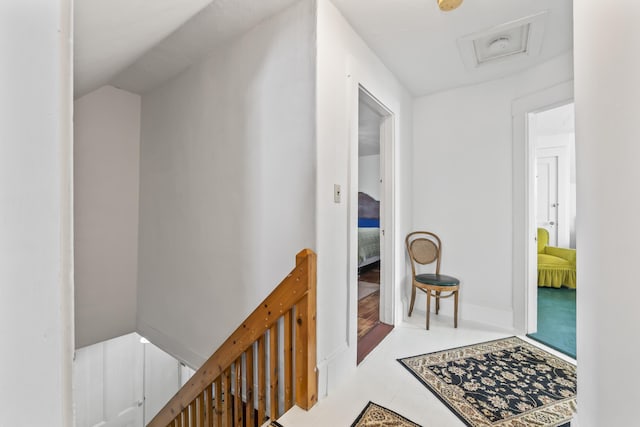 hallway with attic access and an upstairs landing