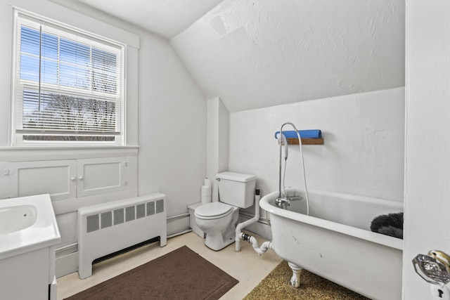 bathroom featuring vanity, toilet, radiator heating unit, a tub, and vaulted ceiling