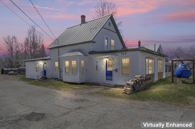 exterior space with entry steps, a chimney, a standing seam roof, and metal roof
