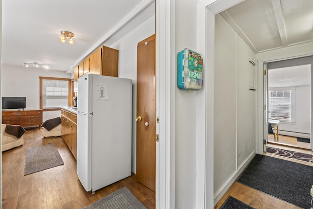 corridor featuring light wood-style floors and a baseboard heating unit