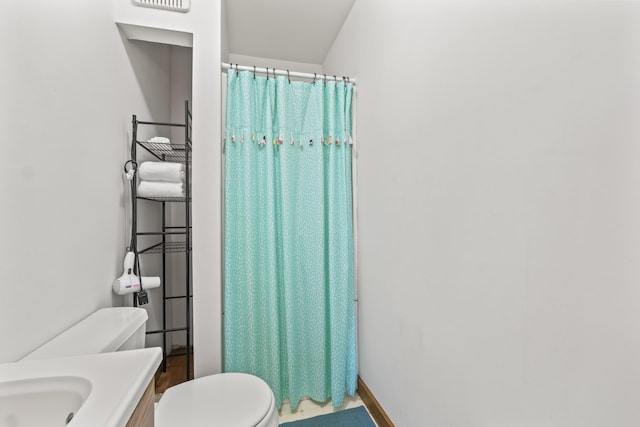 bathroom with toilet, baseboards, curtained shower, and vanity
