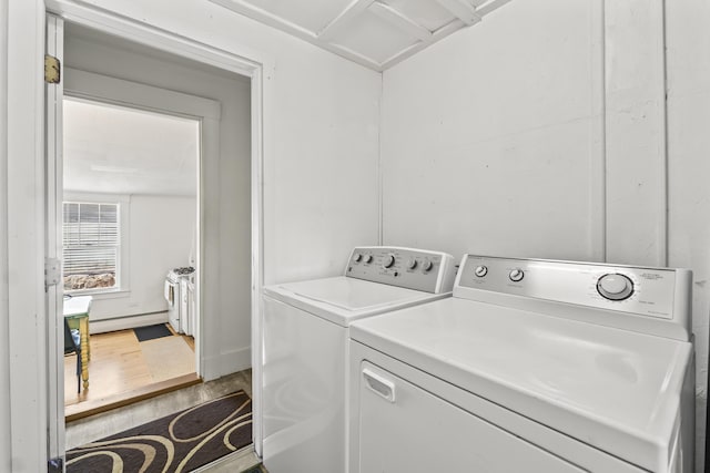 washroom featuring laundry area, wood finished floors, and washer and clothes dryer