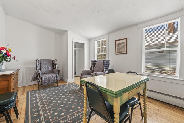 office space featuring ornamental molding, vaulted ceiling, hardwood / wood-style flooring, and a baseboard heating unit