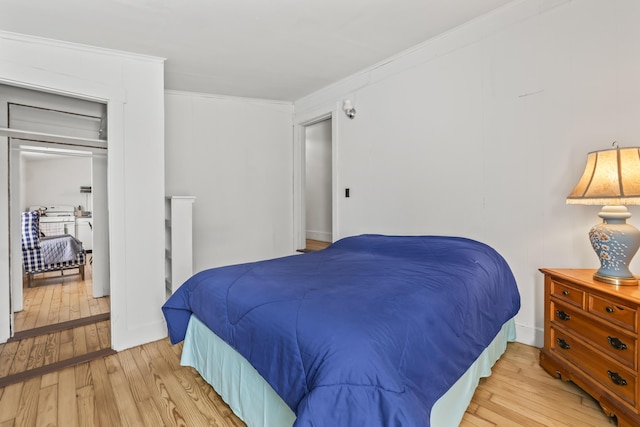 bedroom with crown molding and light wood-type flooring