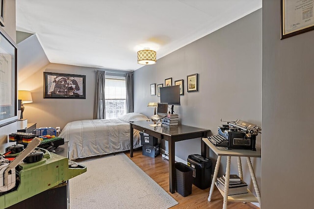 bedroom with light wood-type flooring and lofted ceiling