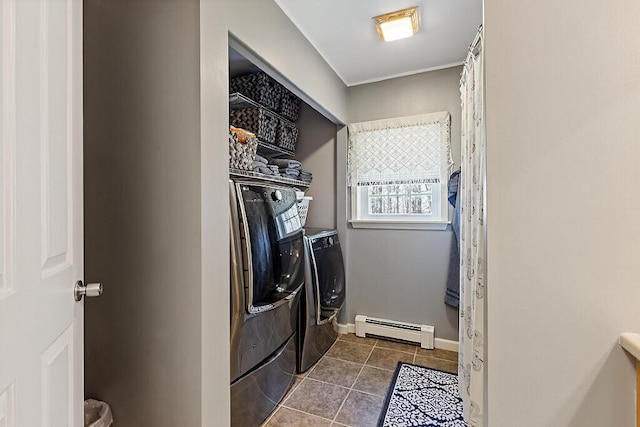 washroom featuring laundry area, baseboard heating, baseboards, dark tile patterned floors, and washing machine and dryer