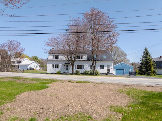 view of front of property with a detached garage, an outdoor structure, and a chimney
