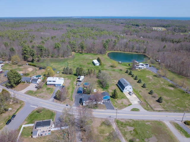 drone / aerial view with a forest view and a water view