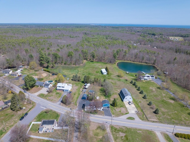birds eye view of property with a water view and a wooded view