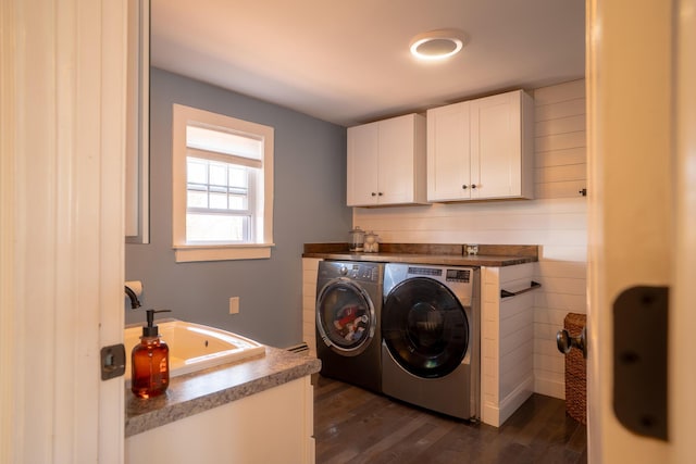 laundry area with a sink, cabinet space, independent washer and dryer, and dark wood-type flooring