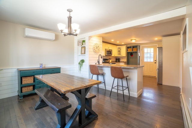 dining area featuring dark wood-type flooring, a chandelier, a wall unit AC, and baseboard heating