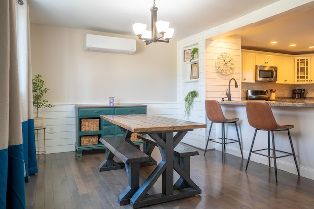 dining room with a wall unit AC, a wainscoted wall, a chandelier, recessed lighting, and dark wood-type flooring