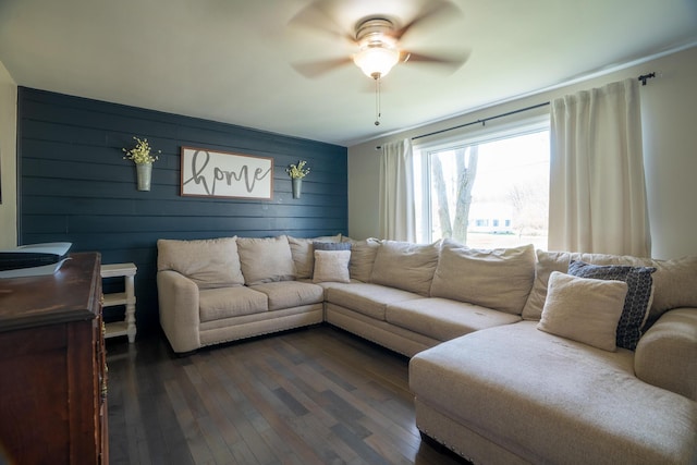 living area featuring a ceiling fan and dark wood-type flooring