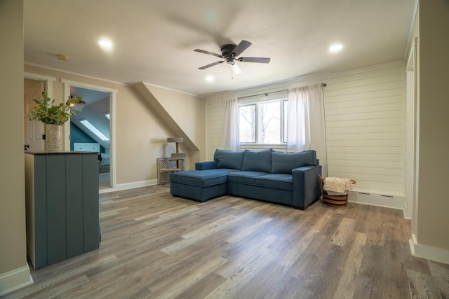 living room with crown molding, baseboards, a ceiling fan, and wood finished floors