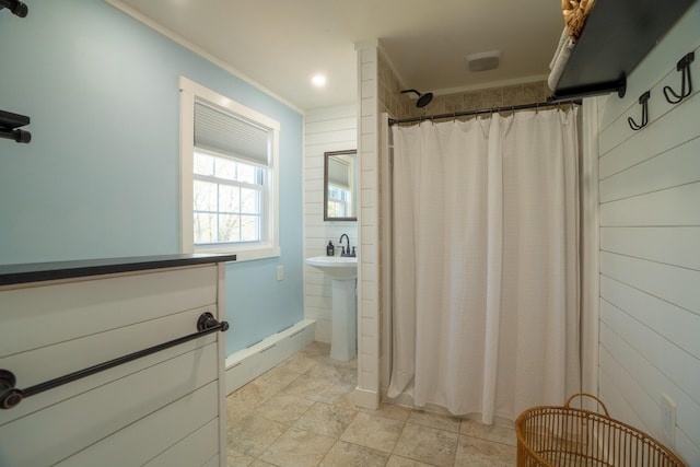 bathroom featuring baseboards, ornamental molding, wood walls, and curtained shower