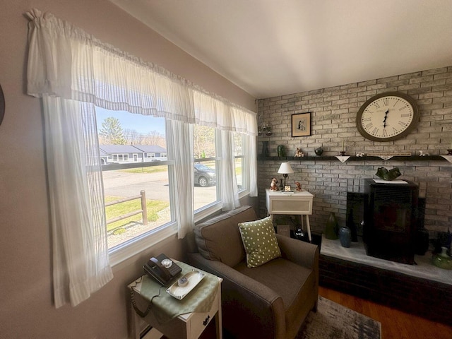 20 Patrick St, Skowhegan, ME 04976 - sitting room featuring a wood stove, wood finished floors, and brick wall