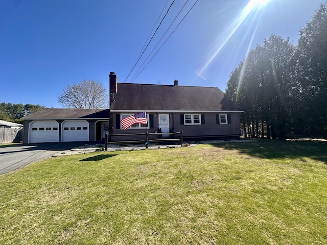 20 Patrick St, Skowhegan, ME 04976 - view of front facade with a chimney, asphalt driveway, an attached garage, and a front yard