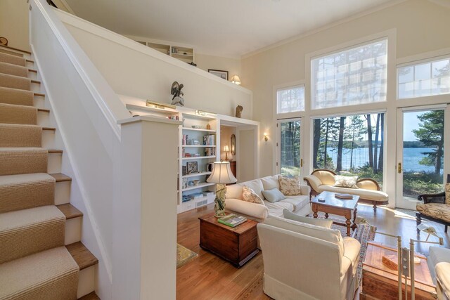 8 Spring Ln, Mount Desert, ME 04660 - living area featuring healthy amount of natural light, a towering ceiling, light wood-type flooring, stairs, and crown molding