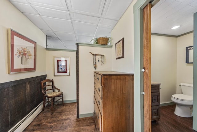 hall featuring dark wood-style flooring, baseboards, and a baseboard radiator