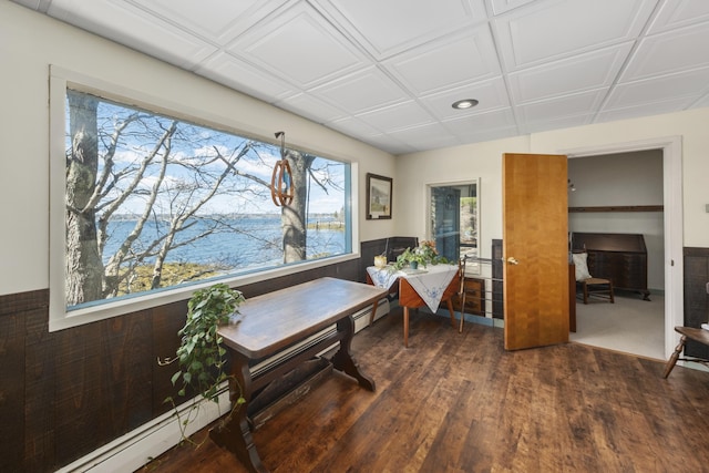 office space featuring a water view, a baseboard heating unit, recessed lighting, and wood finished floors