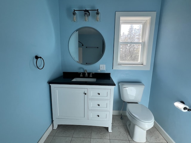 bathroom featuring baseboards, toilet, vanity, and tile patterned floors