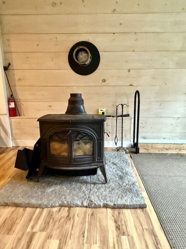 8 Berry Ln, Vinalhaven, ME 04863 - detailed view of a wood stove, wooden walls, wood finished floors, and a fire extinguisher