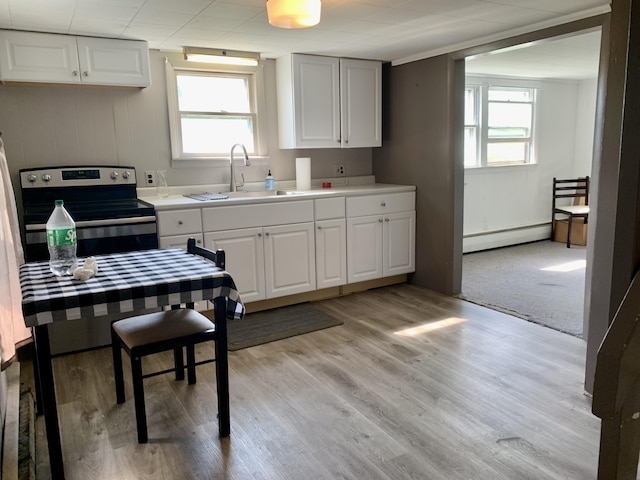 kitchen featuring a baseboard radiator, a sink, a healthy amount of sunlight, and stainless steel range with electric stovetop