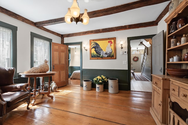 875 N Parish Rd, Turner, ME 04282 - dining area featuring light wood-type flooring, beam ceiling, and a notable chandelier