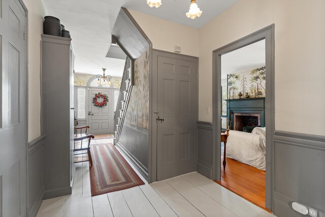 875 N Parish Rd, Turner, ME 04282 - corridor featuring a wainscoted wall, a decorative wall, and a chandelier