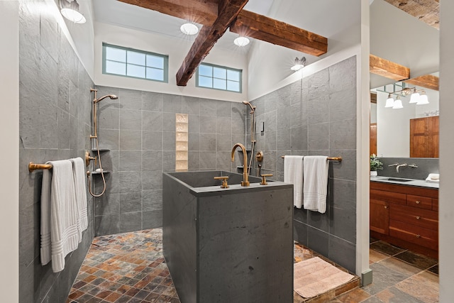 875 N Parish Rd, Turner, ME 04282 - bathroom featuring tile walls, a walk in shower, vanity, beamed ceiling, and stone tile flooring