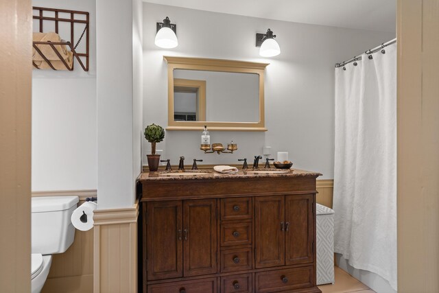 875 N Parish Rd, Turner, ME 04282 - bathroom with double vanity, toilet, a sink, and a wainscoted wall