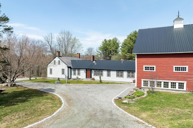 875 N Parish Rd, Turner, ME 04282 - view of front facade with a front lawn, driveway, a chimney, and metal roof