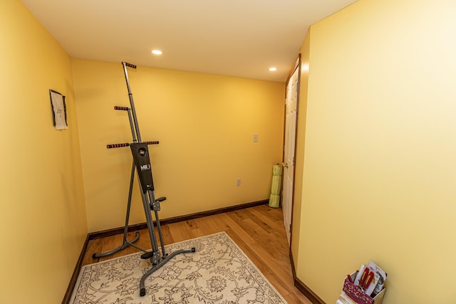 exercise room featuring wood finished floors, recessed lighting, and baseboards