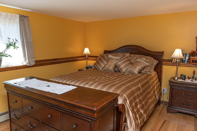 bedroom with light wood-type flooring and a baseboard radiator
