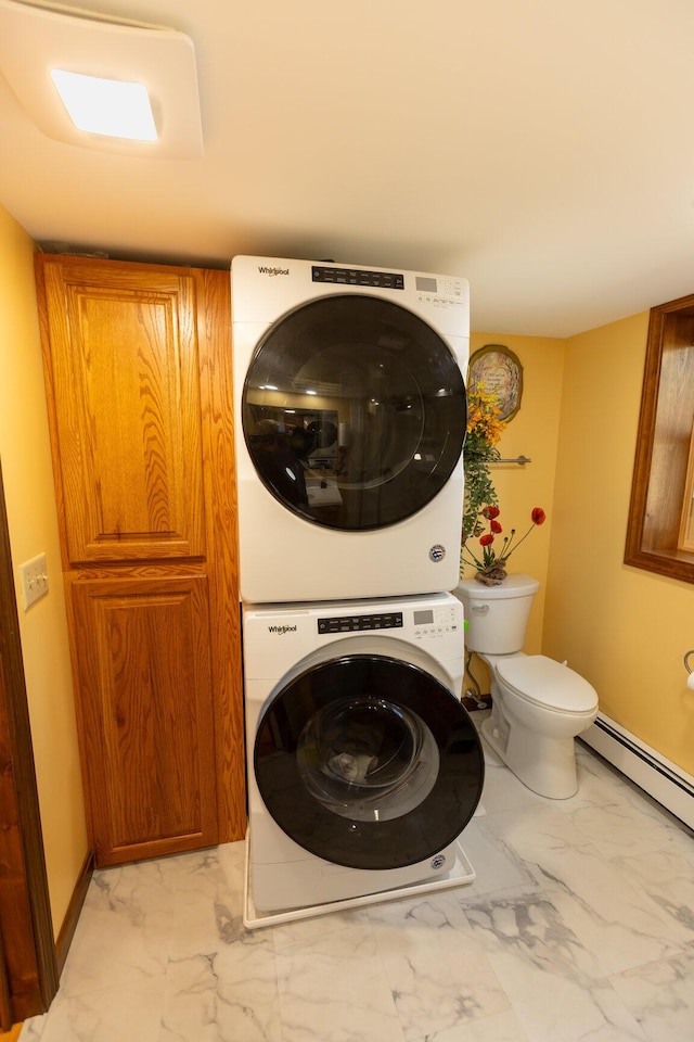 washroom featuring stacked washing machine and dryer, light marble finish floors, and a baseboard heating unit
