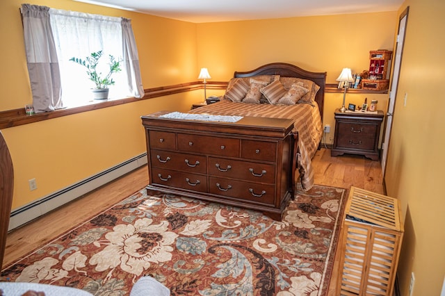 bedroom with a baseboard radiator and light wood-style floors